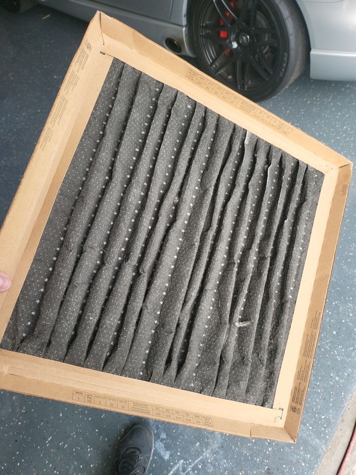 Heavily soiled HVAC air filter clogged with soot and debris after fire